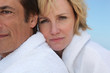 A sad woman clinging to her husband