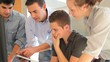Group of students with teacher working on electronic tablet