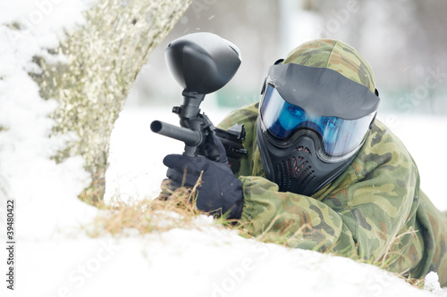 Photo: paintball player with marker at winter outdoors paintball player with marker at winter outdoors