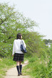 あぜ道を歩く女子高校生