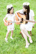 Foto: 草原で楽器を演奏する女性と女の子 草原で楽器を演奏する女性と女の子