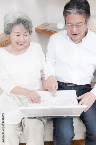 Photo: ノートパソコンを見る笑顔のシニアカップル ノートパソコンを見る笑顔のシニアカップル