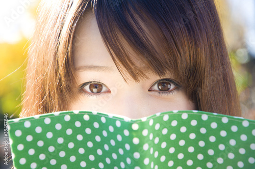 Photo: 文庫本から顔をのぞかせる女性 文庫本から顔をのぞかせる女性
