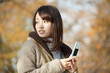 携帯電話を持って振り返る女性