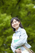 新緑の下で微笑む大学生