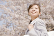 通勤中に桜を見上げるOL