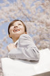 通勤中に桜を見上げるOL