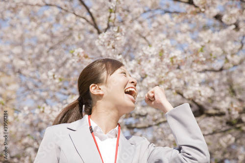 Photo: 桜の下でガッツポーズをする女性 桜の下でガッツポーズをする女性