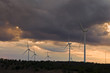windmills on a hill at sunset with clouds
