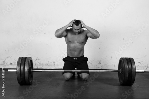 Photo: An athlete is preparing to lift a heavy dumbbell An athlete is preparing to lift a heavy dumbbell
