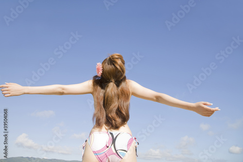 Photo: 浜辺で両手を広げてリラックスしている水着姿の女性 浜辺で両手を広げてリラックスしている水着姿の女性