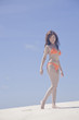砂浜を歩く水着女性