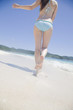 波打ち際を走る水着女性の後姿