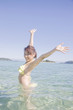 海に入って伸びをする水着女性