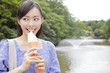 公園でソフトクリームを食べる女性