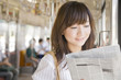 Foto: 電車で新聞を読むOL 電車で新聞を読むOL