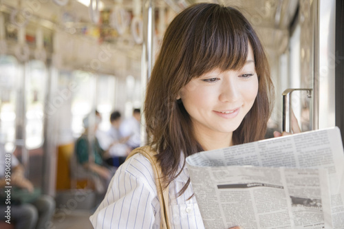 Photo: 電車で新聞を読むOL 電車で新聞を読むOL