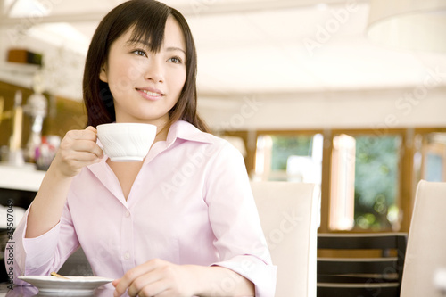 Photo: カフェでティーカップを持つ女性 カフェでティーカップを持つ女性