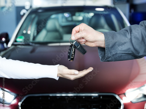 Photo: Key delivery between customer and mechanic in front of new car Key delivery between customer and mechanic in front of new car