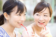 屋外でジュースを飲む女性2人