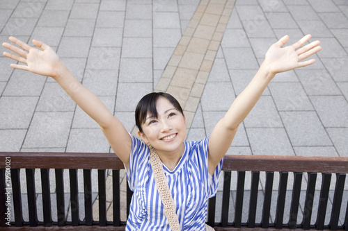 Photo: ベンチに座って両手を広げる女性 ベンチに座って両手を広げる女性