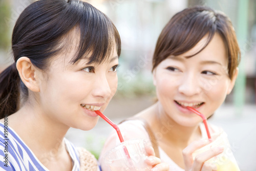 Photo: 屋外でジュースを飲む女性2人 屋外でジュースを飲む女性2人