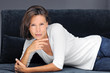 Photo: femme brune sur canapé noir femme brune sur canapé noir