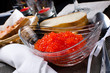 Red caviar in a glass plate next to the bread