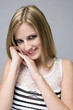 Young blond beauty with mischievious smile.