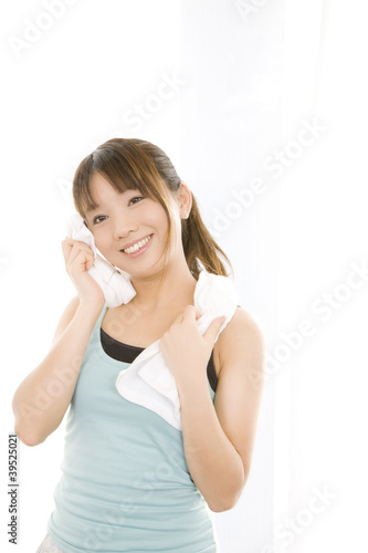 Photo: 顔の汗をタオルで拭いている女性 顔の汗をタオルで拭いている女性