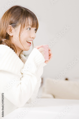 Photo: マグカップを持ちながら笑っている女性 マグカップを持ちながら笑っている女性