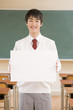 Foto: 教室でホワイトボードを持つ男子中学生 教室でホワイトボードを持つ男子中学生