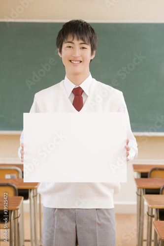 Photo: 教室でホワイトボードを持つ男子中学生 教室でホワイトボードを持つ男子中学生