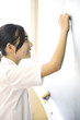 教室の黒板に解答を書く女子中学生