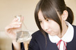 フラスコに入っている液体を見る女子中学生