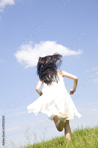 Photo: 草原を走っている女性の後ろ姿 草原を走っている女性の後ろ姿