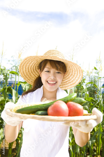 Photo: 畑で採れた野菜を差し出す女性 畑で採れた野菜を差し出す女性