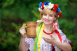 Happy Ukrainian woman with a wooden mug