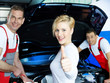 Mechanics working on engine bay, customer shows thumb up
