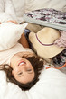 Young woman on the bed indoors unpacking suitcase Young woman on the bed indoors unpacking suitcase