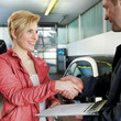 Female customer and master mechanic shaking hands in a garage