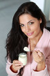 Photo : Jolie femme brune mangeant un yaourt Jolie femme brune mangeant un yaourt