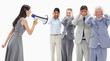 Photo: Woman yelling in a megaphone at business people with their hands over their ears Woman yelling in a megaphone at business people with their hands over their ears