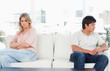 Foto: Woman facing forward and annoyed with crossed arms, while the man looks angry Woman facing forward and annoyed with crossed arms, while the man looks angry