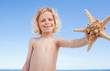 Boy on the beach showing starfish