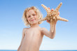Little boy with starfish on the beach