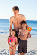 Smiling father on the beach together with his children