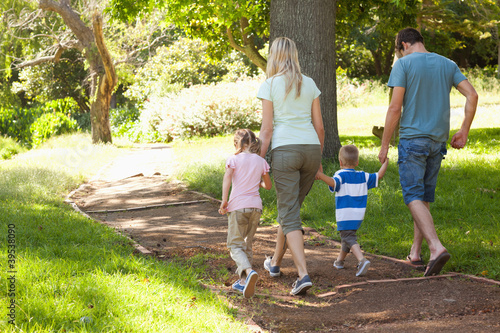 Photo: A happy family walking down a path A happy family walking down a path