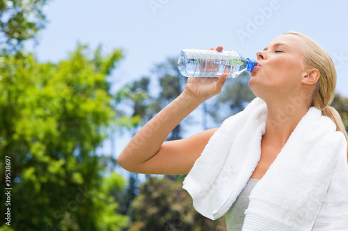Photo: Side view of sportswoman drinking water Side view of sportswoman drinking water
