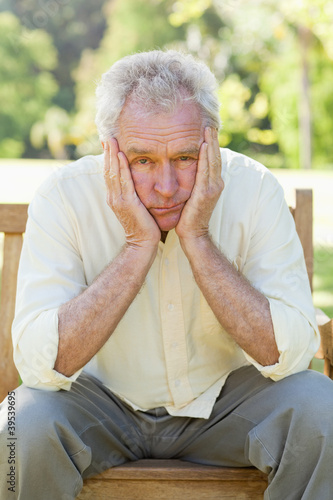 Photo: Disappointed man sitting on a bench Disappointed man sitting on a bench